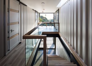 A 14 Series pendant by Omer Arbel for Bocci hangs in the stairwell. The desk at the window was designed by the architects. 