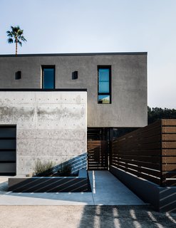 Passersby seeing its parged gray plaster facade would have no clue that the second story of Bret and Dani Stone’s home is made mostly of shipping containers. A crane stacked the units on top of the concrete-and-steel superstructure in a single day in late 2016. Architects Clay Aurell and Josh Blumer, veterans of the medium, sourced the recycled boxes from cor10 Studios.