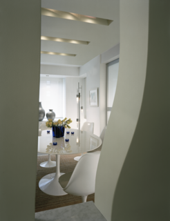 Aside from adding an organic shape to the room, along with a subtle swath of pistachio green color, Hariri’s "folding planes" allow for wiring and lighting of the loft without lowering the whole ceiling area to accommodate the lighting fixtures. The planes gave her a way to drop the ceiling inconspicuously, avoiding harsh lighting over anyone’s head, creating a cozy, connected environment. "No one notices the dropped ceiling," she says. 