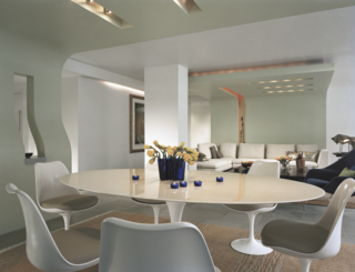 Hariri uses rugs to separate the living and dining areas. While the weaving of the rugs is not similar, she selected harmonious tones so that the carpeting plays well together in the shared space. 