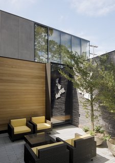 An internal courtyard features Boxwood chairs and coffee table by Janus et Cie. 