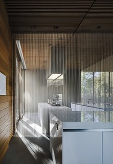 A chain curtain from Cascade Coil separates the kitchen without interrupting sightlines or sunlight. "When you light the outside brighter than the inside at night, it becomes more opaque," says Mark. Bulthaup cabinetry joins appliances by Gaggenau and Miele.