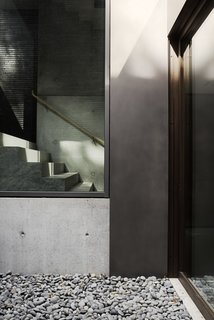 The staircase, which runs from the lower level to the third floor, is lined by a single 32-foot-tall pane of glass. 