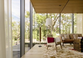 Oak floors, neutral furnishings, and an area rug by Han Feng for Tai Ping warm the office, as does the view of surrounding treetops. "You really feel as if you’re in the canopy," says architect Takashi Yanai. A vintage Louis Vuitton trunk serves as a coffee table. 