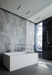 The Statuarieto–walled master bathroom features a Comfort Mood tub by Boffi with taps by Vola; the shower fixtures are by Dornbracht.