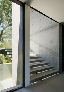 The stair treads are structural steel clad in stone over a steel plate stringer created by West Edge Metals.