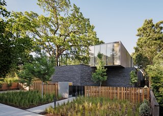 Working with a sumptuous material palette, Ehrlich Yanai Rhee Chaney Architects designed a sprawling new residence in Palo Alto for Mark and Laura Pine. The teak wood and handmade Danish bricks that define the exterior are used inside as well; distressed stainless steel panels by Chris French Metal sheathe one side of the upper volume. Blasen Landscape Architecture chose Peruvian feather grass to flank the entrance walkway. 