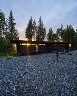 In Carnation, Washington, Kim and Lou Maxon and their three boys reside in a horizontal, steel-clad house designed by the renowned firm Olson Kundig. Its south end is slightly raised above the bare landscape, accessible via a bridge. 
