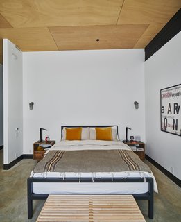 In the master bedroom, the steel bed from Room & Board is framed by two nightstands from West Elm.