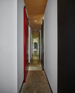 Barn-style doors hung from tracks by Richard Wilcox line the hallway. 