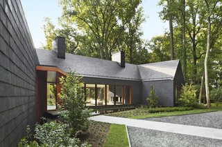 When Marlene and E. Dale Adkins’s home of 22 years, a 1960s ranch house in Greenspring Valley, Maryland, was lost in a fire in 2013, the couple vowed to rebuild. Finished last year, their new home is covered in dark slate shingles for the sides and roof, Cor-Ten steel accents, and charred cedar for the gable fronts. 
