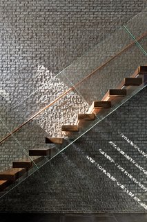 Duratherm windows paint the black brick wall of the staircase with sunlight. 