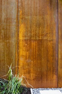 Weathered steel retaining walls hold in the slope. 