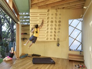 A climbing wall on the ground floor mimics the playful atmosphere of a children's tree house.