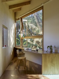 A small workspace overlooks the surrounding garden.