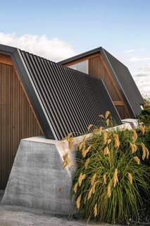 The retaining wall anchors the standing-seam steel roof. 