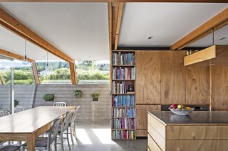 In the kitchen/dining area, the range hood and cooktop are by Fisher & Paykel; the Navy chairs are by Emeco. 