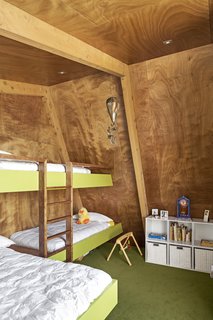 Beneath the pitched roof, there’s a bedroom with custom bunks for visiting grandchildren. 