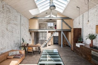 Built as a warehouse, this 2,200-square-foot, one-bedroom home in East London kept its original layout, but now has an open bedroom on the mezzanine level.
