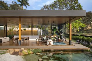 Beyond the living room and deck, a natural pool filled with koi fish serves as a unique focal point for the tropical garden. 