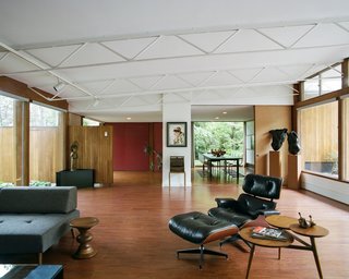 In the living room, the slanted, open-joist ceiling rises to almost 10 ½ feet. A fusuma door leads <br>to the dining room. The torso sculptures are by Janice Trimpe. 