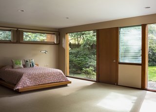 A custom duvet in a Girard pattern covers the master bed; the sconce is original.