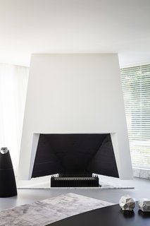 The futuristic fireplace, designed by Engels, is flanked by a BeoLab 20 speaker by Bang & Olufsen.