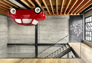Vehicle Wall Art supplied the loft’s most unusual feature, a 1965 Fiat Nuova 500 F mounted upside-down on the ceiling. Magnetic panels of blackened and waxed steel display smaller artworks. The floating stairs replaced a ramshackle set of steps.
