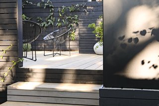 The cedar decks were left to bleach in the sun for one summer and then finished with a light gray wash. Metal Solair chairs are in keeping with the tricolor palette of black, white, and green. 