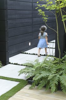 Hana Bea, 6, follows the concrete pavers that lead from the front yard to the side entrance.