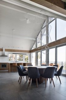 The dining room suspension light is a custom design by Robert Franco. The dining chairs are by West Elm.