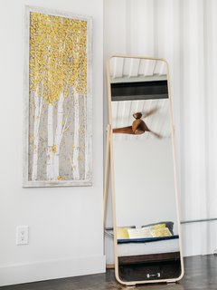 A fan by Big Ass Fans can be seen in the reflection of the bedroom mirror.