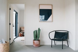 The reading space in the living room features a Louise Gray print and a Menu Afternoon Lounge Chair. Snowe Outdoor Throws are provided in the basket for chilly nights. Here, we get a glimpse of the lounge chair by Stone and Sterling in the background. 