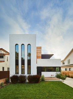 The building's crisp, white facade nods to the neighboring white stucco homes that were constructed in the 1920s and 1930s. The elongated arched windows give the exterior a 1920s Art Deco feel.