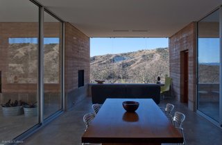 Steel and glass combine with rammed earth to create a home that is both connected to the landscape, and distinctive from it. "It can be really striking when the sun hits it, and there's a little glare," says Rick Joy. "It's like any body of water in the desert."