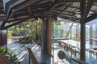 A choice of dining areas, either partially protected or enclosed with glass and light wooden louvers. 