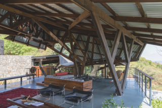 A complex, angled structure shades and protects the main outdoor living space.