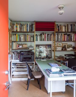 The space holds a library of books and a work table for two.