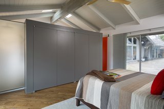 Fein was tasked with reimagining a master suite in a ranch house in Mission Hills, Kansas. A wall of handleless cabinets serves as the closet, subtly dividing the space from the bath area.