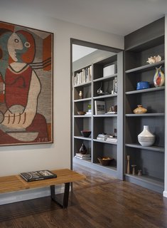 Transitioning from the eating bar, a wall of bookshelves carries through the space.