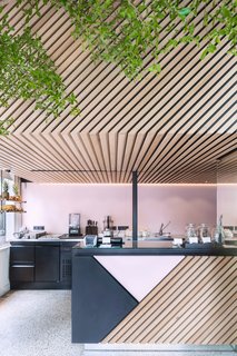 Designed by Standard Studio, the graphic store uses a palette of black and pink powder-coated metal and diagonally aligned wood slats. Photo by Wouter van der Sar.