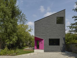 The house has a striking facade: The sharply angled roofline eschews conventional geometries. Though the shingles resemble tradition cedar, the structure is in fact clad in a durable and fire-proof roof shake manufactured by Enviroshake that doesn't require any maintenance after installation. The finishing touch is a bright pink stucco cutaway for the entrance. The color was chosen as a nod to Gustavo's Mexican heritage.