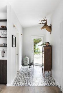 Jujol Basalto porcelain tiles, sourced from Mettro Source, line the floor just inside the front entry.