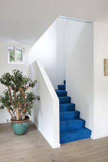 Cobalt blue carpet by Object Carpet leads to the second floor.