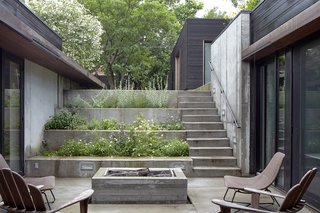 Nature Reigns Supreme at a Verdant Kansas City Home - Photo 4 of 9 - A stepped concrete garden planted with herbs and flowers marks the descent to the house. The courtyard is the focal point of the U-shaped structure; there is clear visibility between the kitchen on one side and the children's bedrooms on the other.