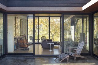 Nature Reigns Supreme at a Verdant Kansas City Home - Photo 5 of 9 - Large sliding doors connect the living room to both the courtyard and a covered porch on the western side of the house.