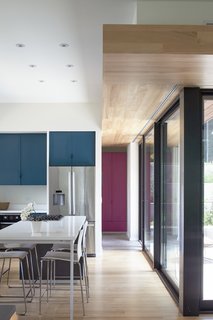 Nature Reigns Supreme at a Verdant Kansas City Home - Photo 7 of 9 - The interiors are outfitted with beech floors and soffits. Custom laminate cabinets in varying colors create storage throughout the home.
