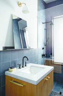 The bathrooms are outfitted with Jason Wu for Brizo fixtures. The Bestlite BL7 wall lamp by Robert DudleyBest for GUBI hangs above a marble-topped vanity.