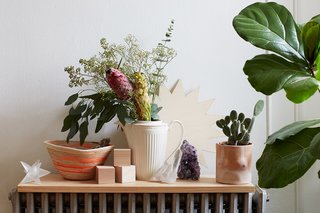 One vignette, propped on a radiator, features a pot by Isaac Nichols, a rope basket by Trish Andersen, and a crystal from Sprout Home.