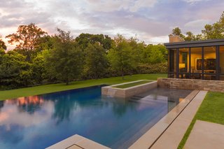 To enhance the home's floating effect, the rear yard features a pool that conceptually emerges from additional small pools of water that extend from under the house. Once the water reaches the backyard, it then flows over the infinity edge and back onto the landscape. Courtesy of Marvin Windows and Doors.